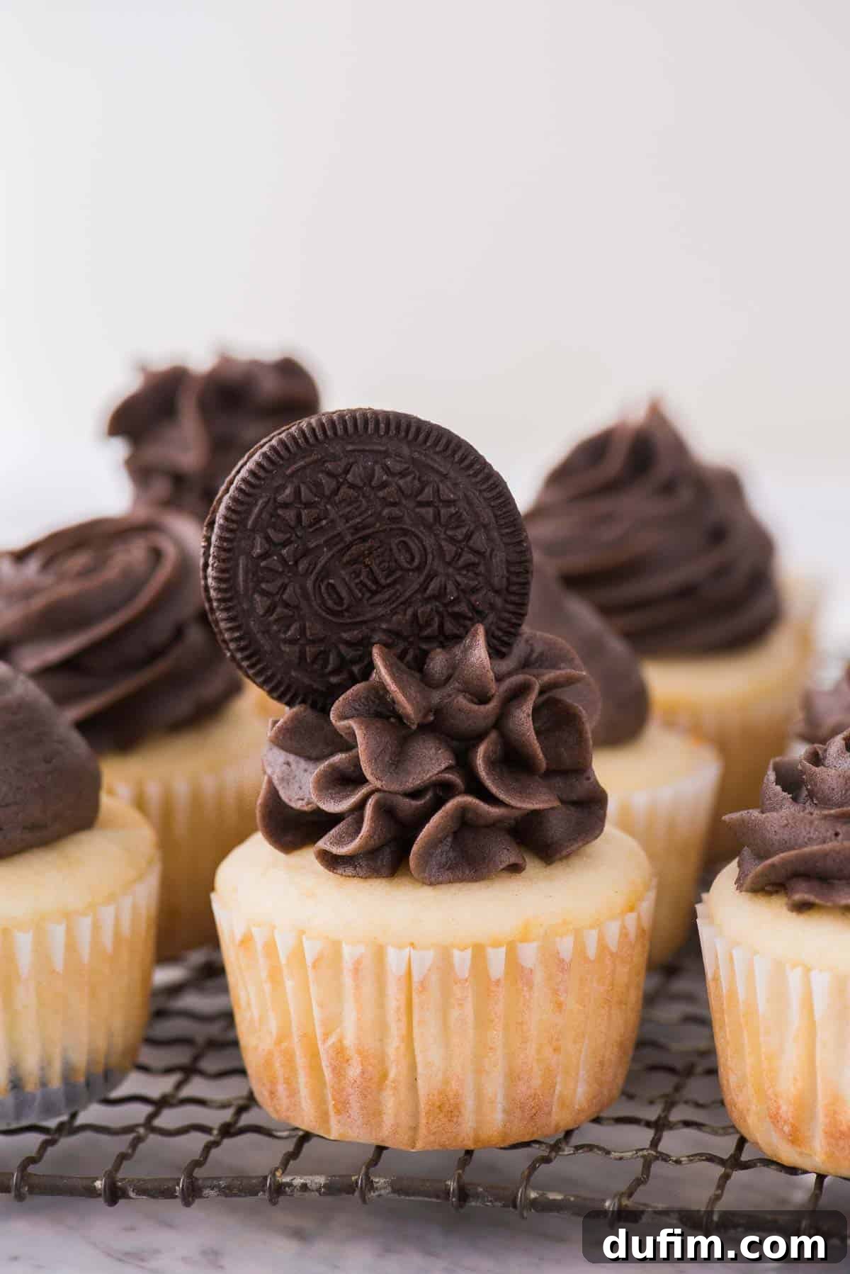 Oreo Cookie Crust Cupcakes 4 Vanilla cupcakes with Oreo frosting, topped with a whole Oreo, arranged on a wire rack