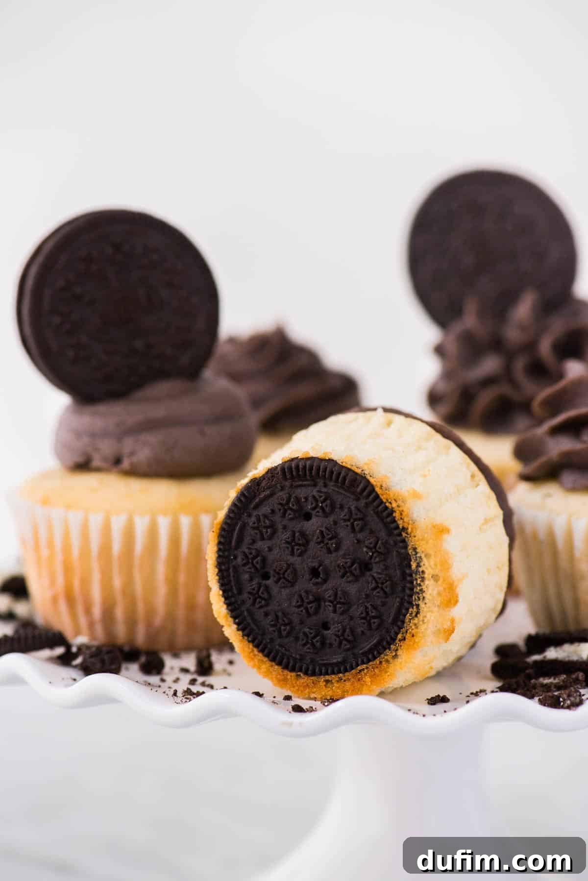 Oreo Cookie Crust Cupcakes 6 Vanilla Oreo bottom cupcakes on white cake stand on white background, ready to be served