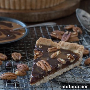 A close-up of the delicious Turtle Tart, swirled with caramel and chocolate and topped with pecans and sea salt.