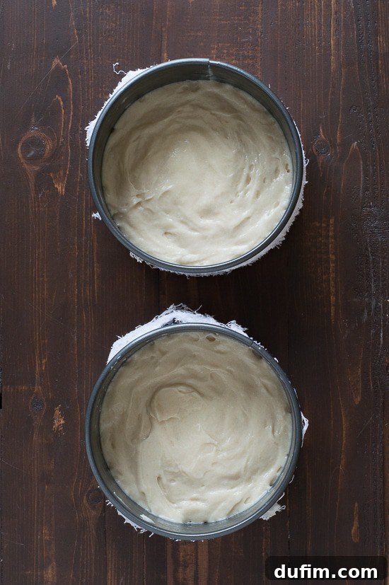 Dividing cake batter evenly into prepared pans