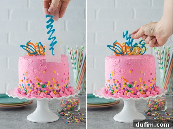 A close-up of the top of a Pink Confetti Chocolate Chip Cake, showcasing personalized chocolate writing that spells out a celebratory message, surrounded by colorful sprinkles.