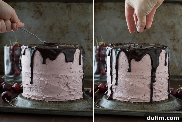 A stunning three-layer white cake with cherry buttercream filling, topped with a rich chocolate ganache drizzle and garnished with fresh cherries.