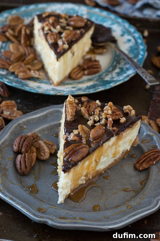 Overhead shot of a beautifully decorated whole turtle cheesecake, glistening with ganache and caramel, ready to be sliced.