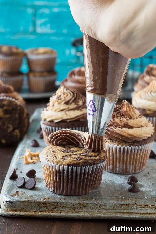Chocolate Peanut Butter Bliss Cupcakes 4 A trio of swirled chocolate peanut butter cupcakes with rich, piped frosting and chocolate sprinkles.