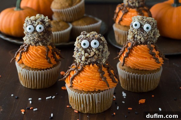 Collection of Pumpkin Walnut Spider Cupcakes with Halloween decorations.