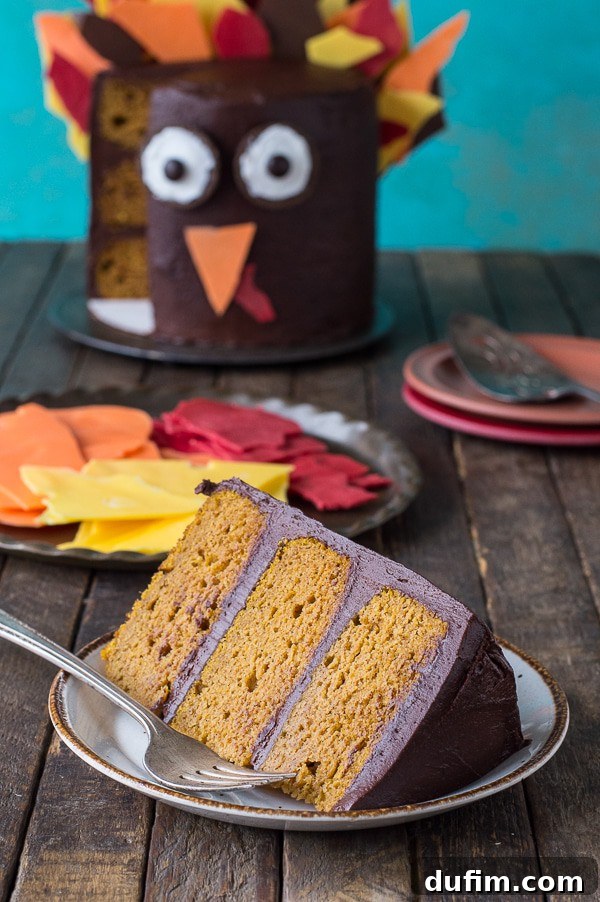 A delightful close-up of the 3-layer pumpkin chocolate turkey cake, highlighting the intricate arrangement of colorful chocolate shard feathers.