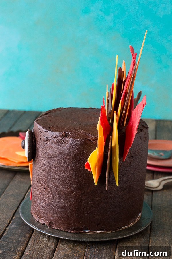 A close-up side view of the Thanksgiving turkey cake, illustrating how the chocolate shard feathers are artfully inserted into the cake's frosting.