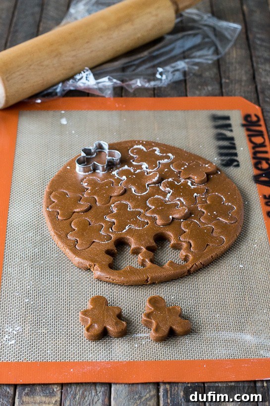 Gingerbread Spice Ready-Slice Cookies 7 Rolling and cutting brown gingerbread dough for the inner shapes of Slice N’ Bake Cookies.