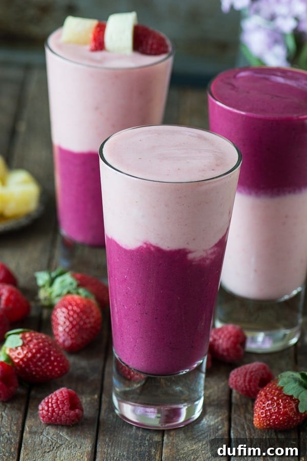 Hand holding a two-layer berry beet smoothie, perfect for a healthy Valentine's Day