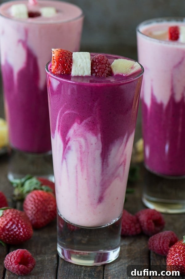 Finished layered berry beet smoothie served in clear glasses