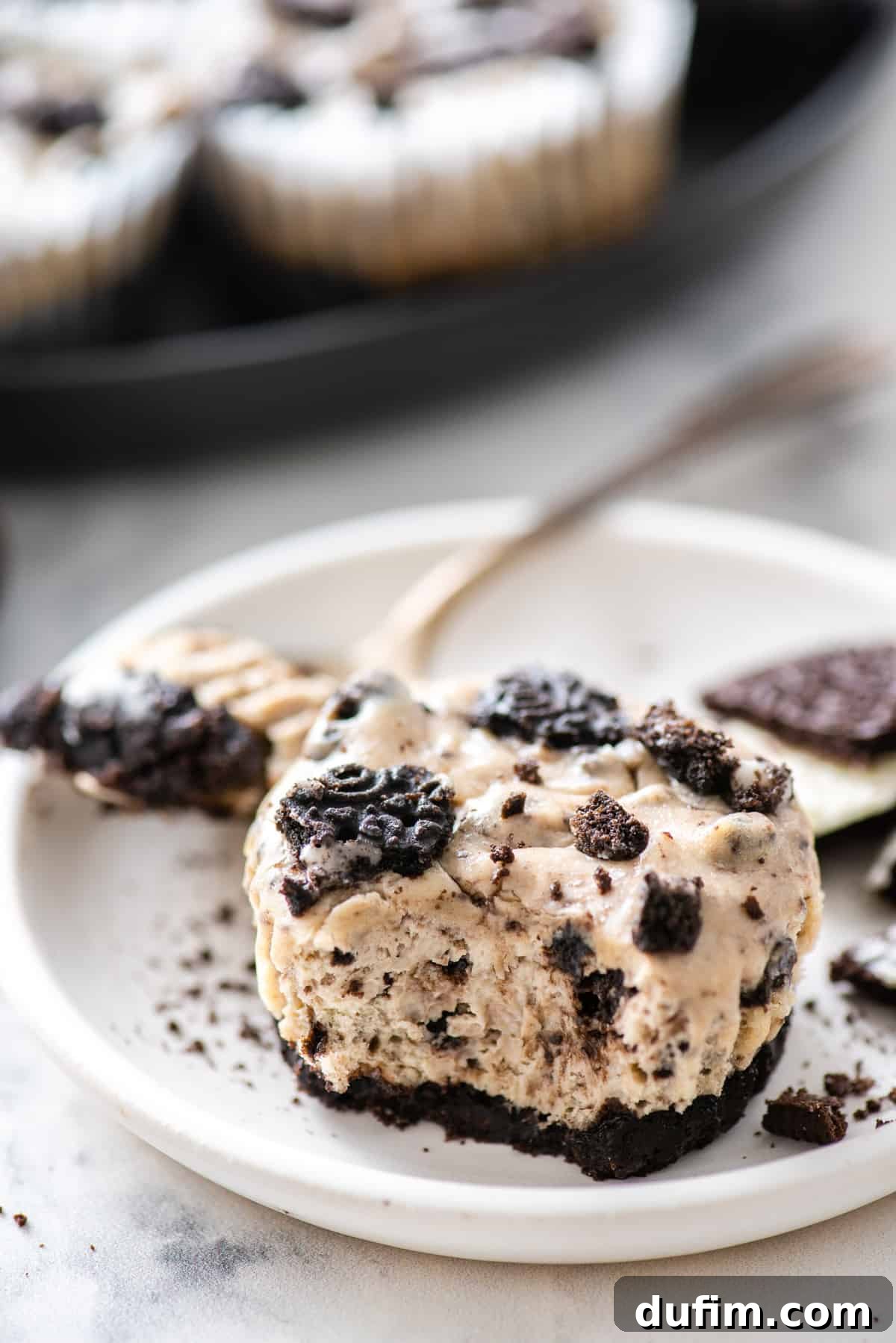 mini oreo cheesecakes on white plate on white background