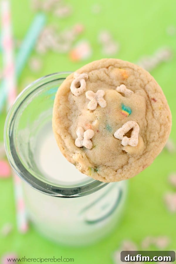 Irresistible White Chocolate Lucky Charms Cookies artfully presented in a clear glass cup of milk.