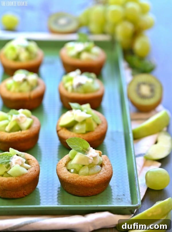 Refreshing Green Fruit Salad Cookie Cups arranged on a vibrant green serving platter.