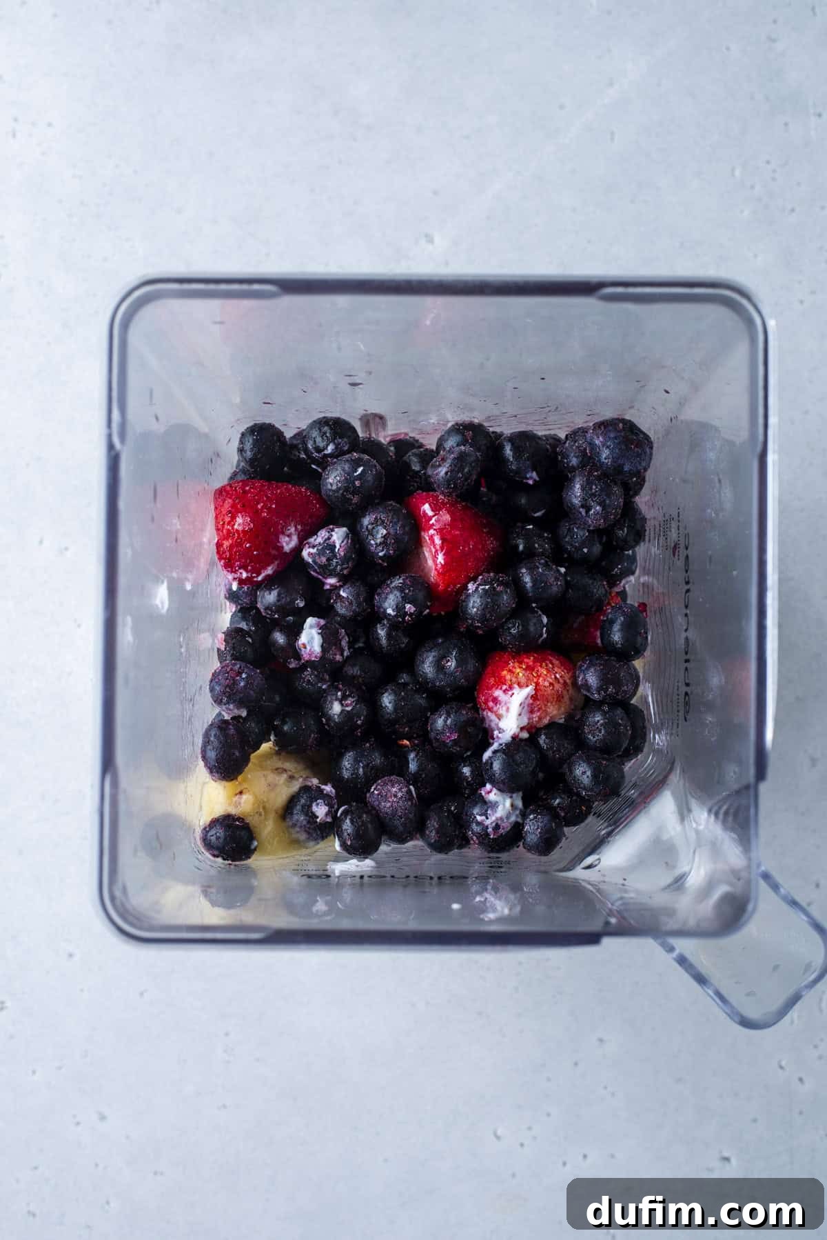 Colorburst Smoothie Delight 15 Frozen mixed berries, including strawberries, blueberries, and raspberries, are blended to create a deep purple smoothie layer.