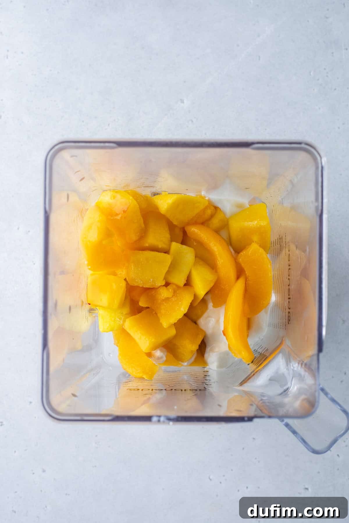 Colorburst Smoothie Delight 7 The orange smoothie layer, a blend of peaches and mango, swirls in the blender, promising a sunny hue.