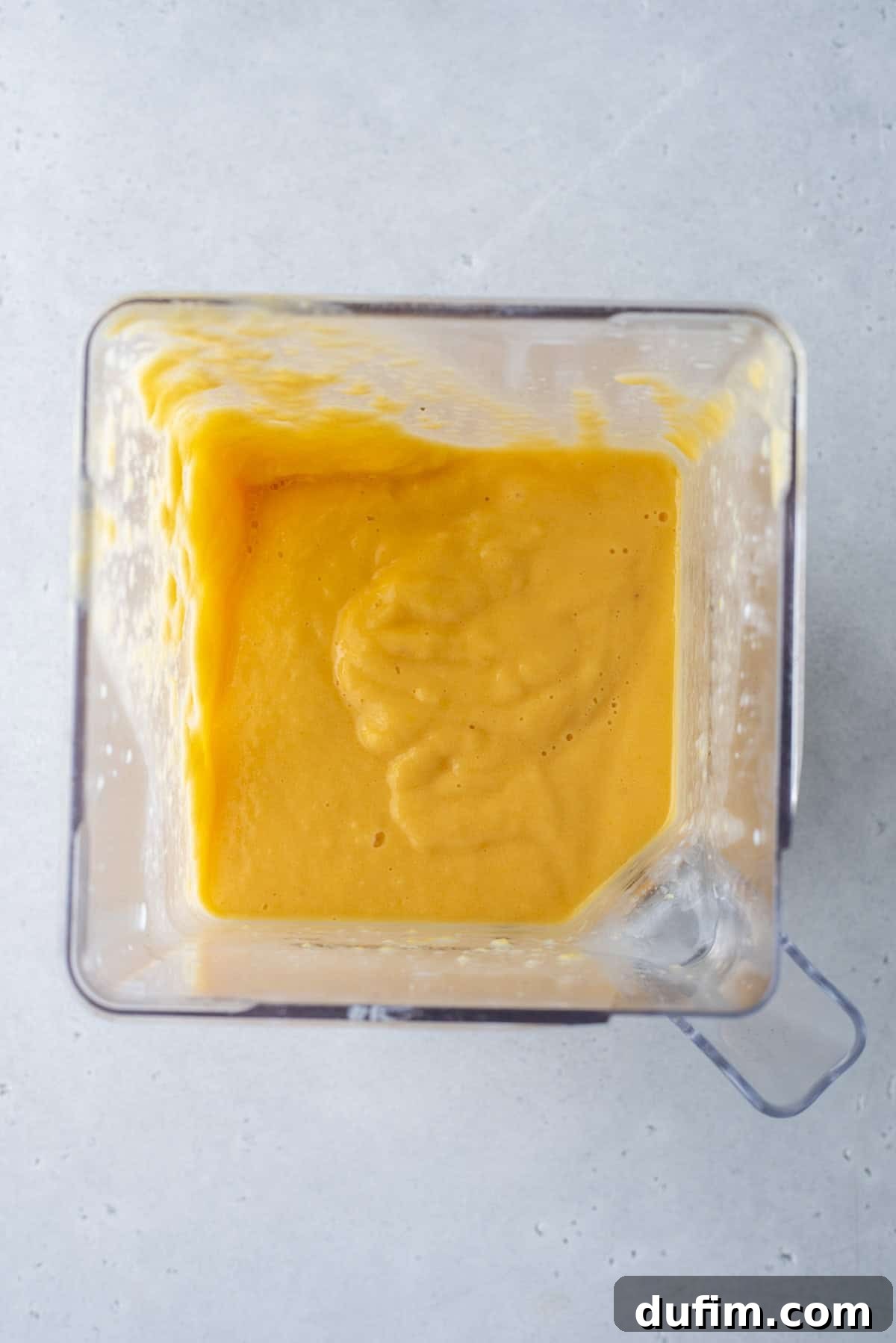 The distinct orange layer is carefully added on top of the red layer in the glass, showcasing the beautiful color separation.