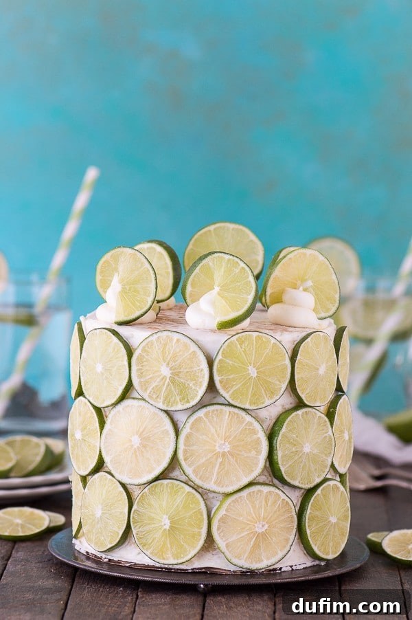 A stunning coconut lime cake with fresh lime buttercream and elegant lime slices adorning its sides, ready for a fun presentation.