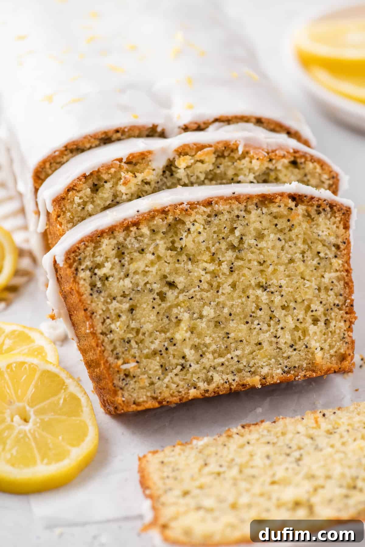 A beautifully sliced loaf of glazed lemon poppy seed bread, showcasing the perfect texture and inviting glaze.