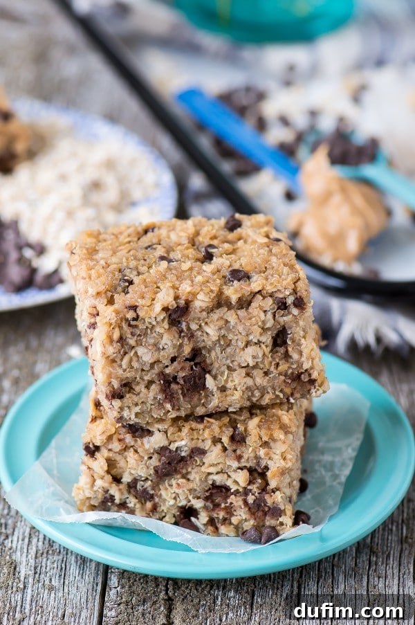A Delicious & Healthy Snack Option Two enticing Homemade Peanut Butter Chocolate Chip Quinoa Granola Bars, artfully presented on a small blue plate on a rustic wooden table.