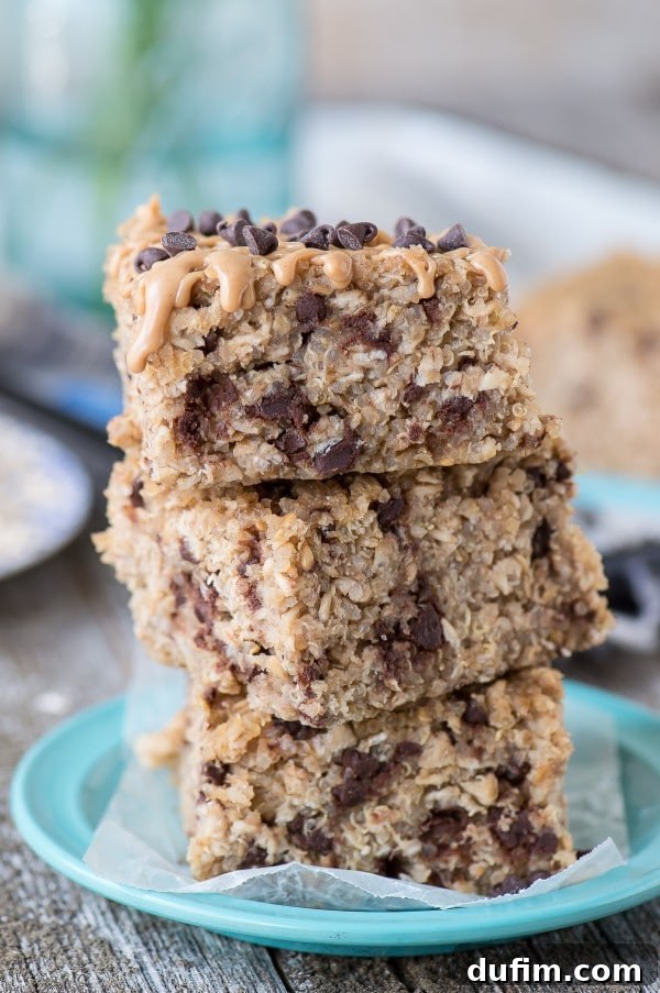 Versatile & Easy Quinoa Granola Bars Three perfectly stacked Healthy Peanut Butter Chocolate Chip Quinoa Granola Bars, ready to be enjoyed on a charming small blue plate.