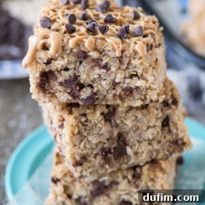 Three homemade Peanut Butter Chocolate Chip Quinoa Granola Bars on a blue plate, ready to be enjoyed.