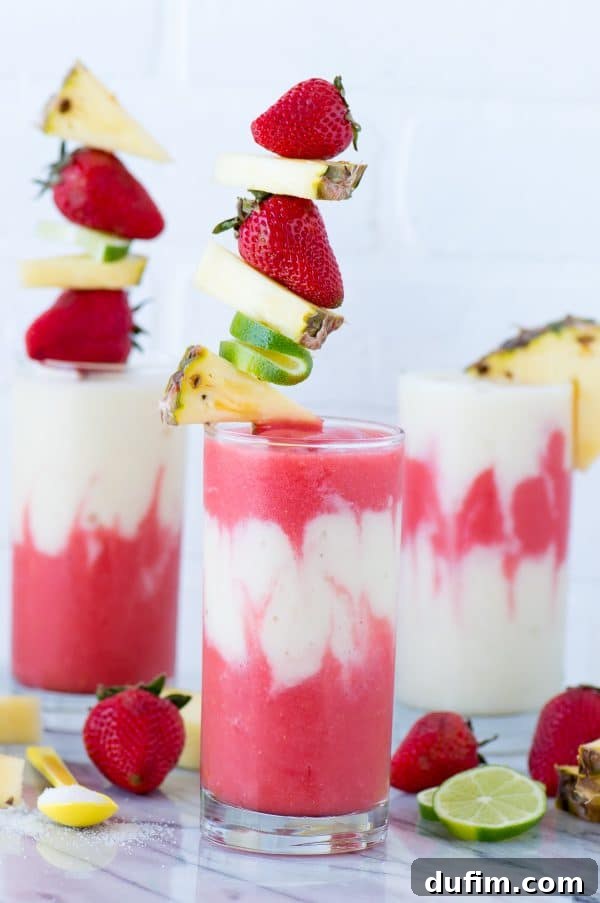Three Miami Vice Mocktails in glasses, showcasing the distinct red and white layers, ready to be enjoyed. A perfect tropical beverage for sharing.