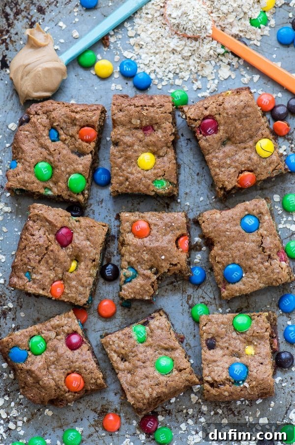 Close-up shot of a healthy monster cookie bar, highlighting the texture and colorful candies.