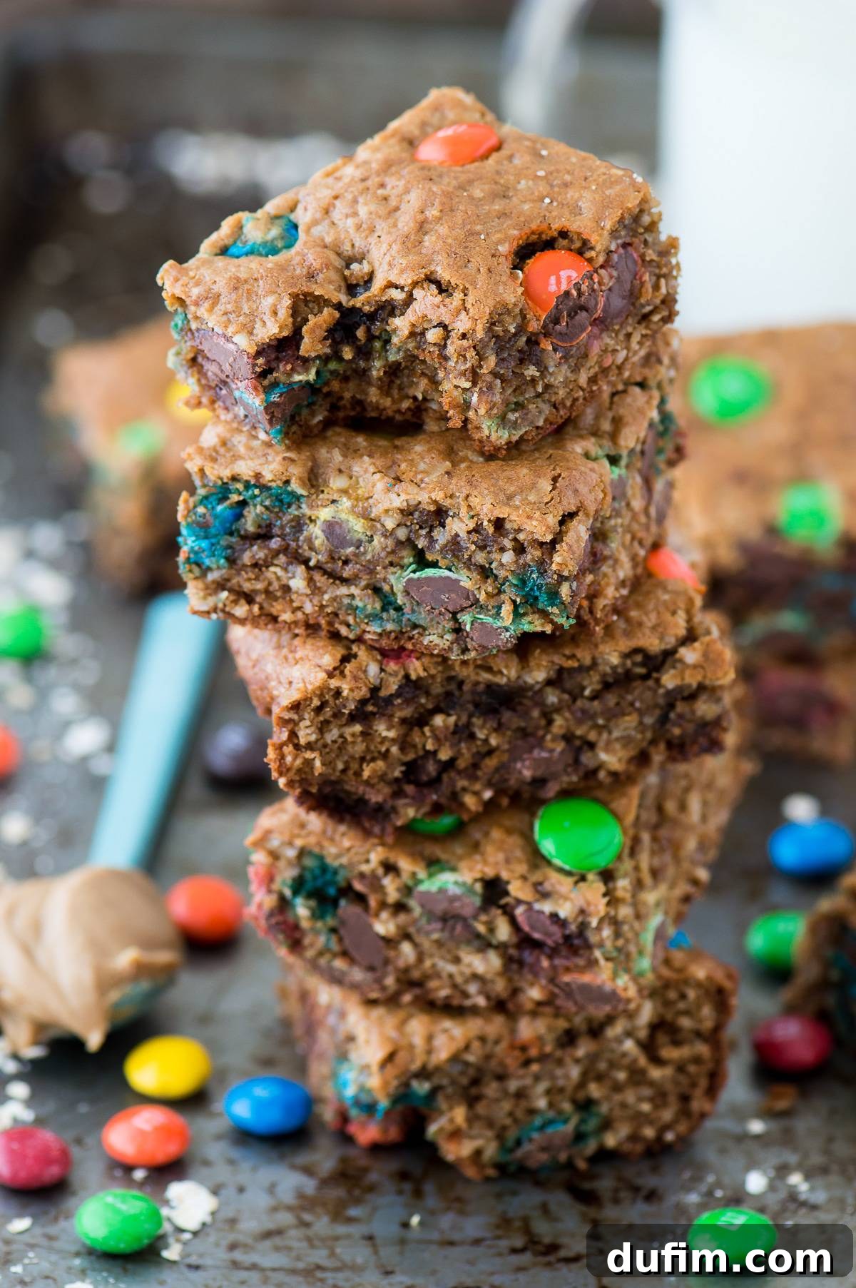 Freshly baked healthier monster cookie bars cooling on a wire rack, ready to be sliced and enjoyed.