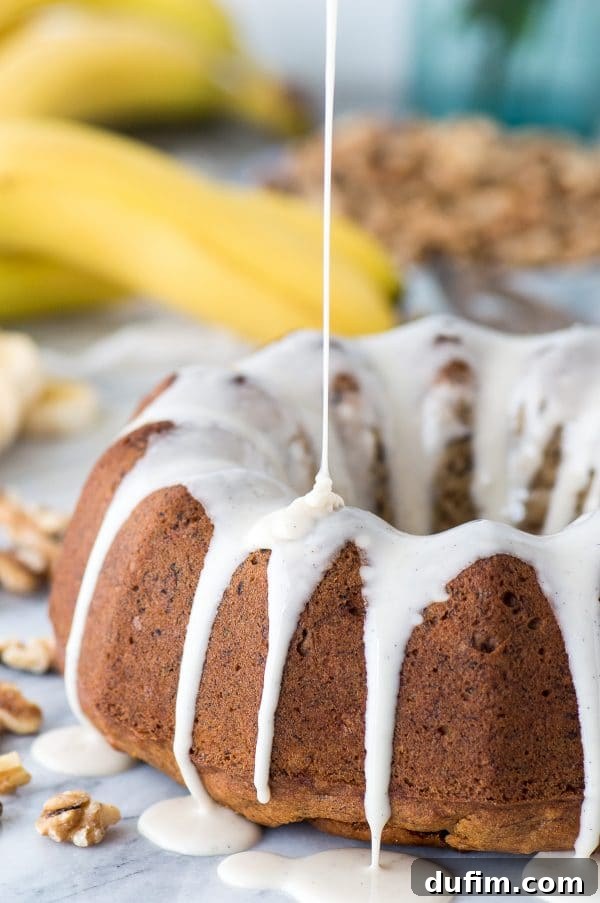 A beautifully presented slice of one-bowl banana nut bundt cake, revealing its moist texture and walnut pieces.