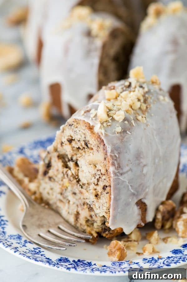 An overhead view of the finished banana nut bundt cake with vanilla bean glaze, decorated with walnuts.