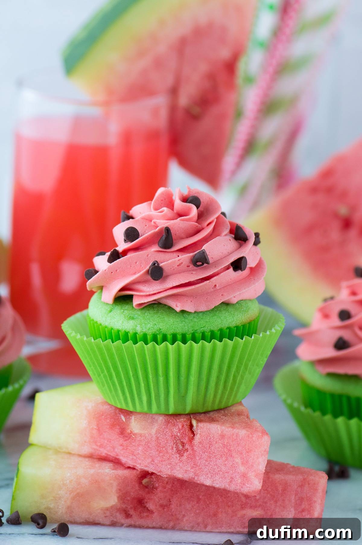 Watermelon Burst Cupcakes 5 Four perfectly frosted watermelon cupcakes in bright green liners, arranged elegantly on a marble surface, ready for a party.