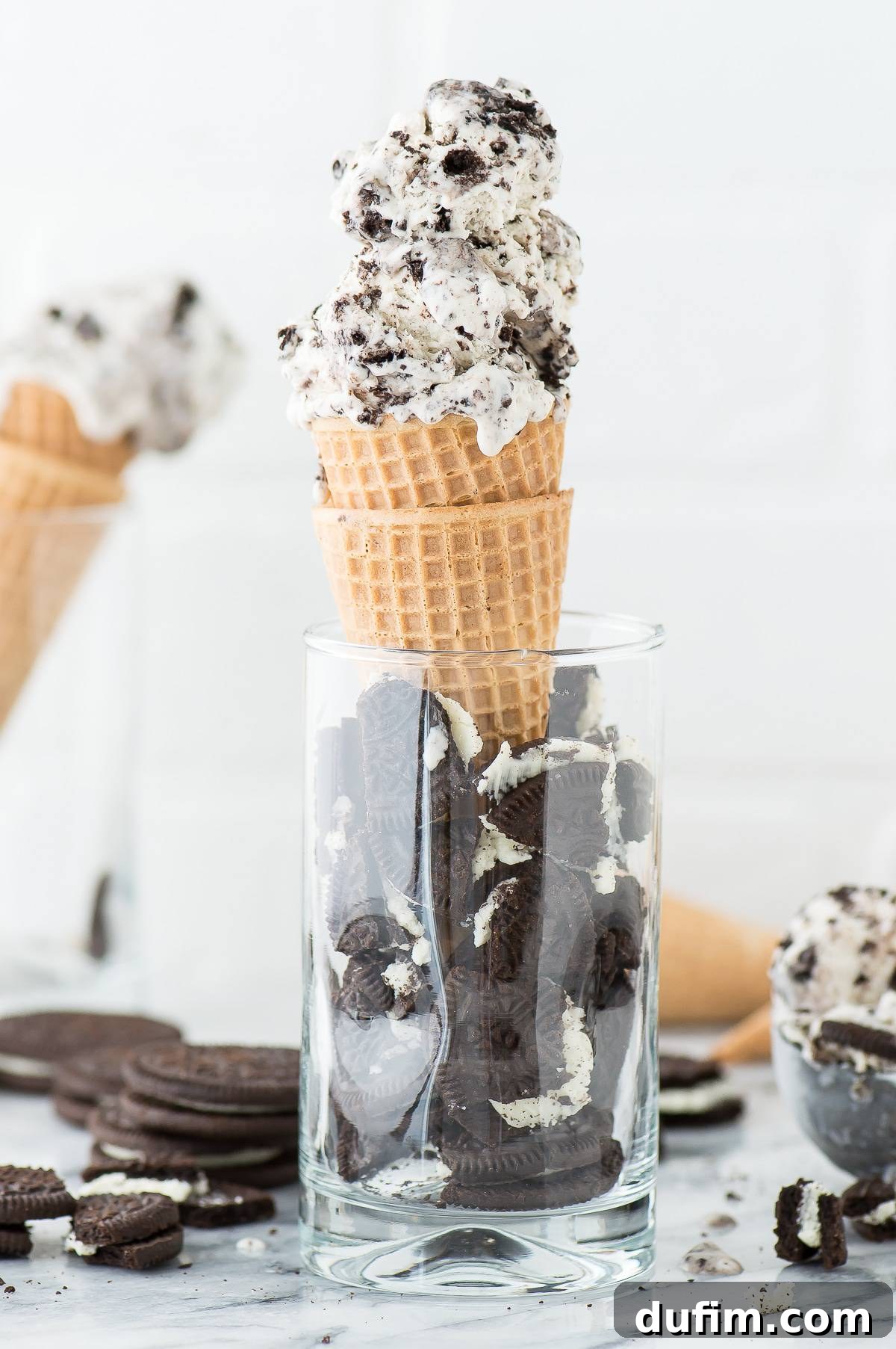 3 Ingredient Oreo Ice Cream artfully presented in two waffle cones, nestled within a glass filled with broken Oreos, creating an appealing dessert display.
