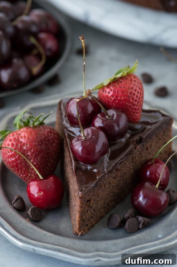 Luscious Berry Mud Cake 3 A beautifully decorated chocolate mud cake featuring a smooth ganache glaze and a generous topping of fresh berries, captured from above.