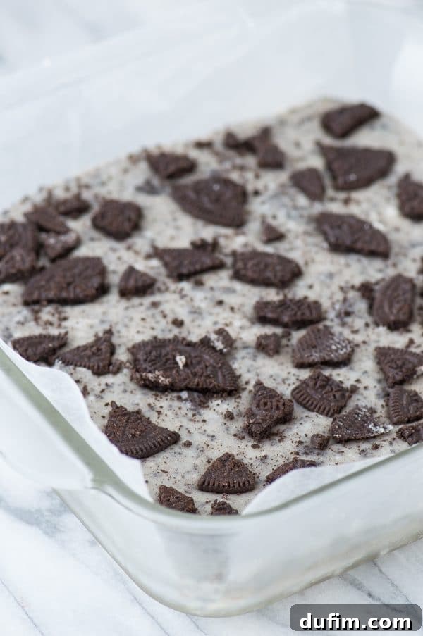 Peanut Butter Oreo Explosion Fudge 3 Close-up of the two-layer peanut butter Oreo fudge with a spoon taking a bite.