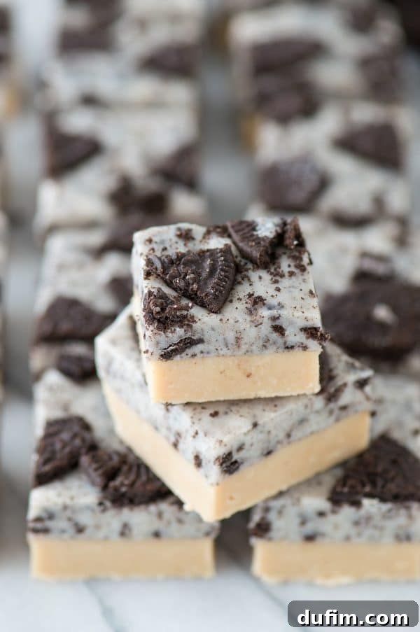 Peanut Butter Oreo Explosion Fudge 4 Sliced squares of homemade peanut butter Oreo fudge on a serving plate.