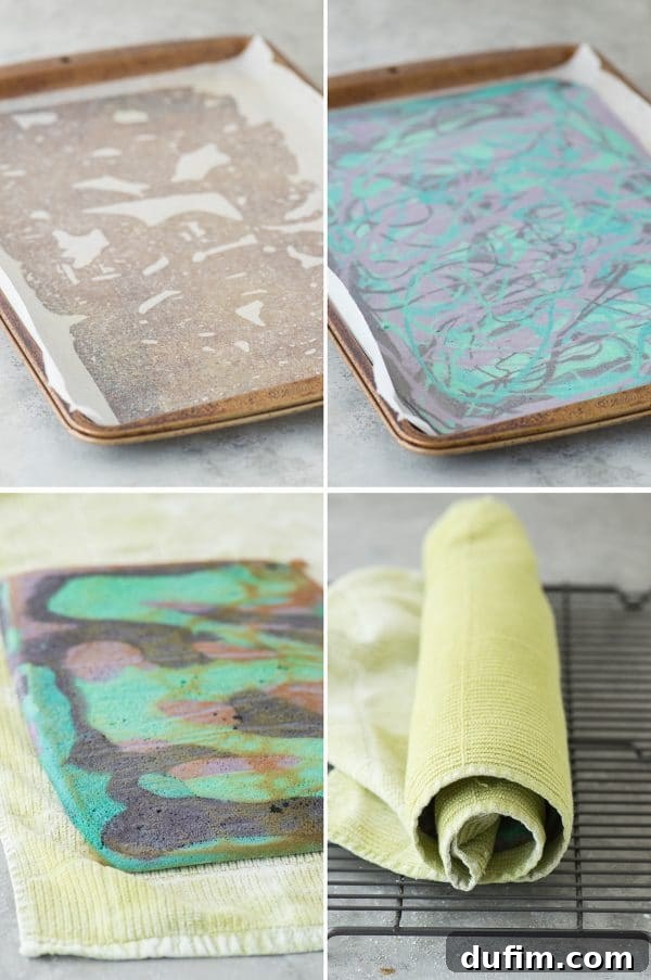 The multi-colored cake batter drizzled into a parchment-lined jelly roll pan, showing the initial swirling of purple, blue, teal, and black before baking.