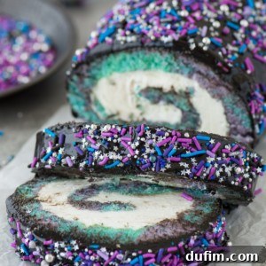 Multi-colored galaxy cake roll with black chocolate ganache, topped with sprinkles!