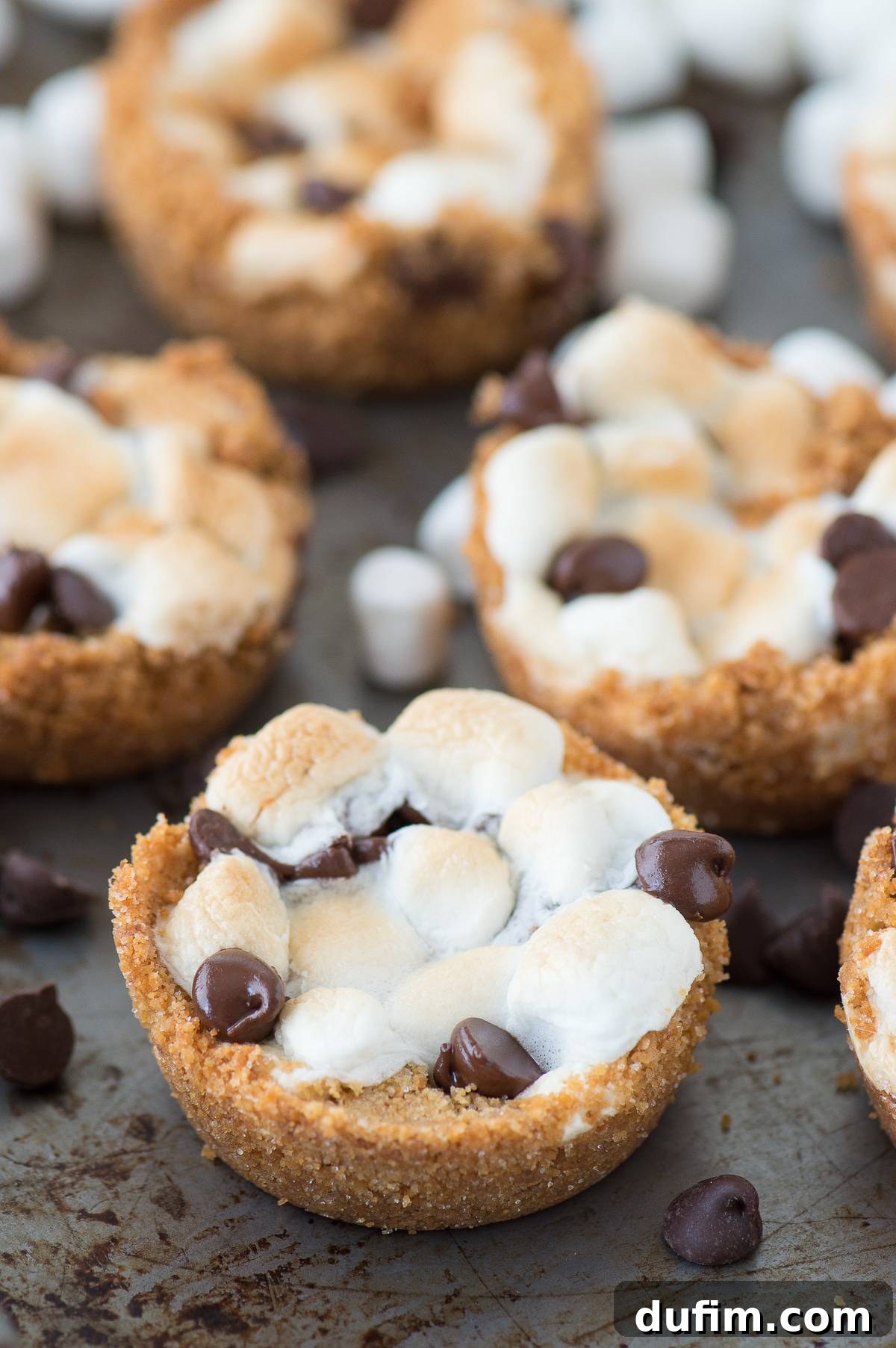Smores Delight Cups 8 A delightful arrangement of four 5-ingredient indoor S’mores Cups on a baking sheet, showcasing their perfectly toasted marshmallows and ready-to-eat appeal.