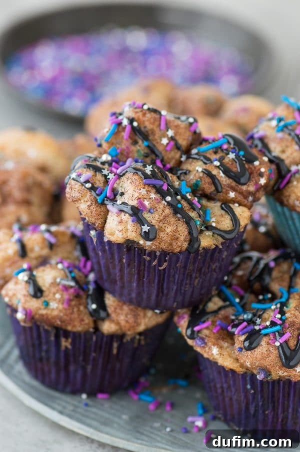 A close-up of golden-brown Galaxy Monkey Bread Muffins in a muffin pan, ready to be glazed, showcasing the individual pull-apart pieces.