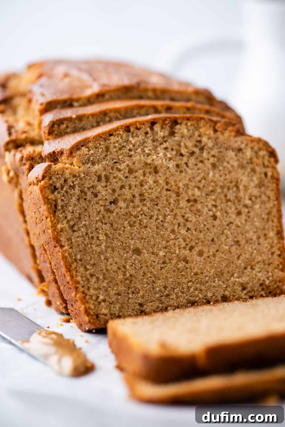 Another view of a sliced peanut butter bread loaf on a white background, highlighting its texture