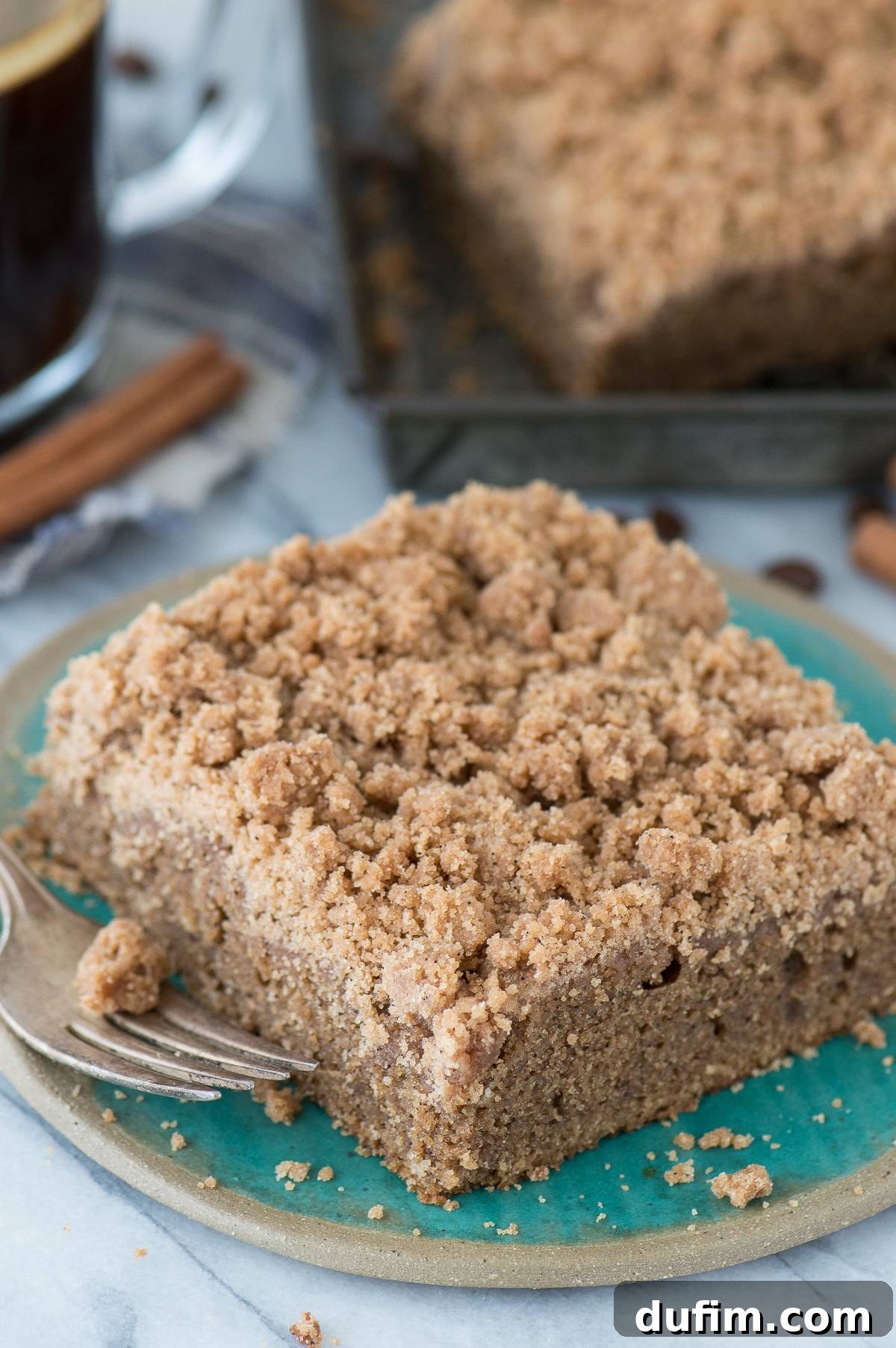 A large slice of Espresso Coffee Cake with a dense layer of crumb topping, served on a white plate, highlighting its indulgent layers.