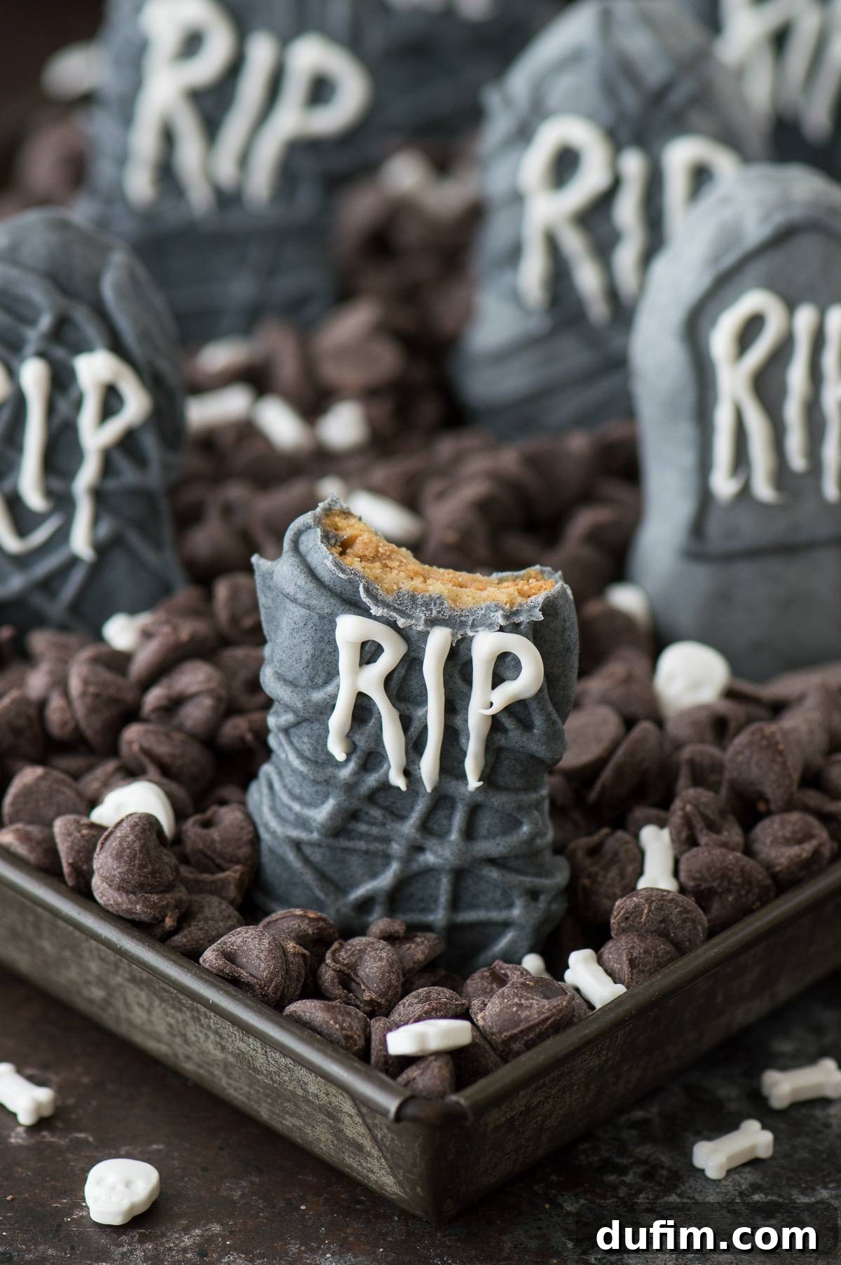 Eerie Nutter Butter Graveyard Treats 6 Nutter Butter Tombstones displayed in a spooky chocolate chip graveyard with skeleton bone sprinkles, perfect Halloween party food.