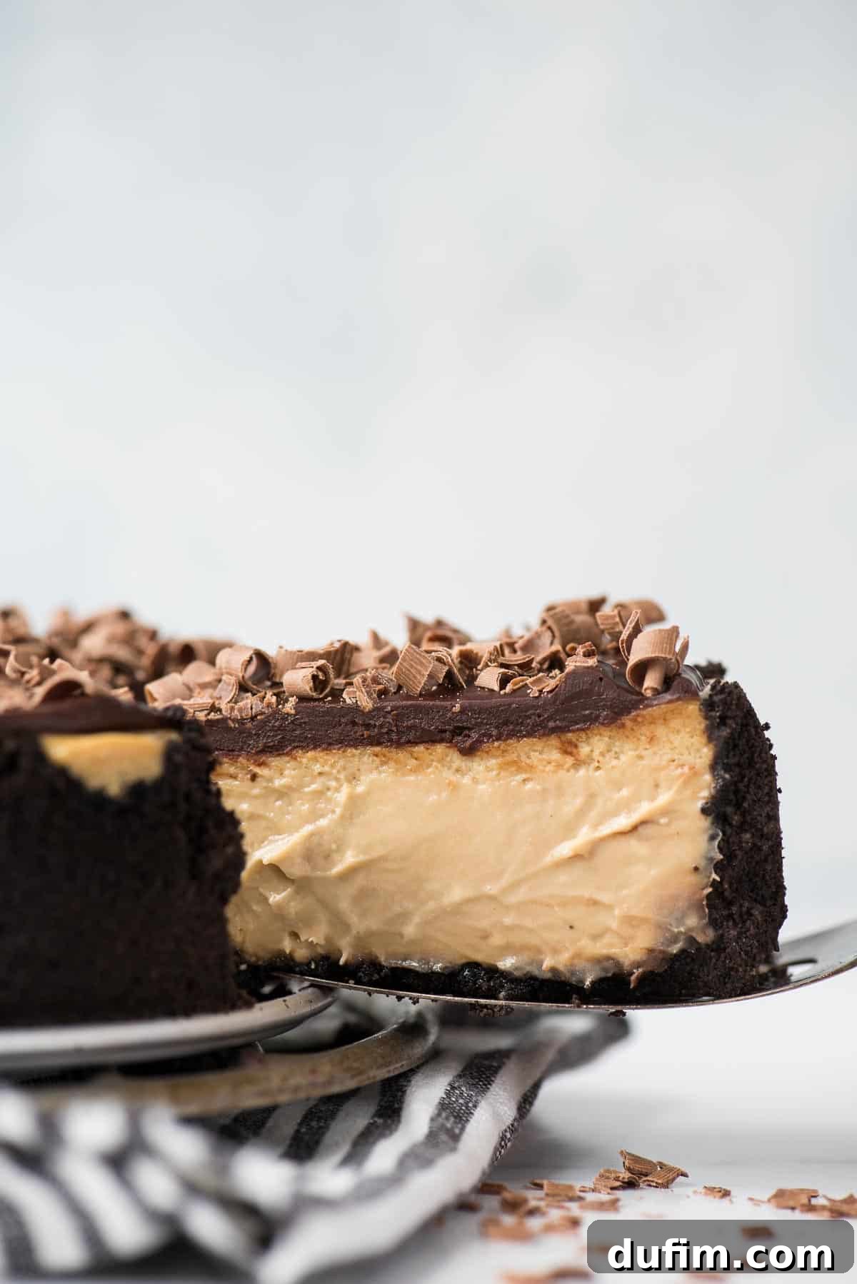 A perfectly sliced piece of espresso cheesecake on a serving spatula, showing its creamy layers.