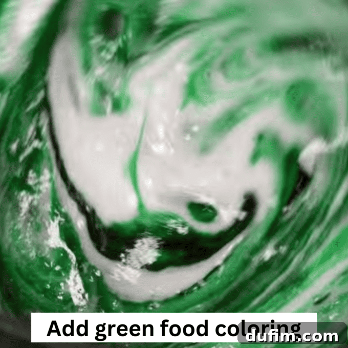 Golden No-Bake Wonders 6 Vibrant green food coloring being meticulously added to the melted marshmallow and butter mixture in a pot, ready to be stirred for perfect Christmas wreaths.
