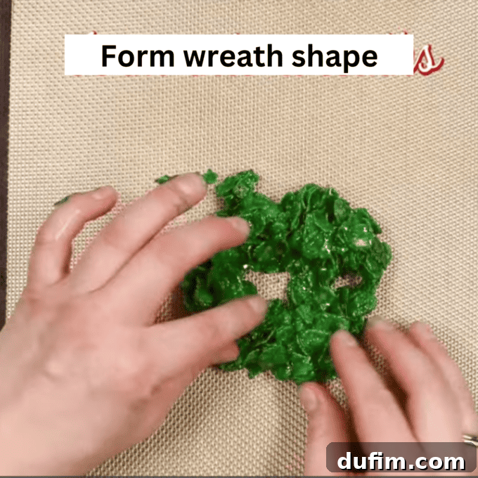 Golden No-Bake Wonders 10 A finger gently creating a central hole in a flattened cornflake disk, meticulously forming the classic wreath shape on a baking sheet.