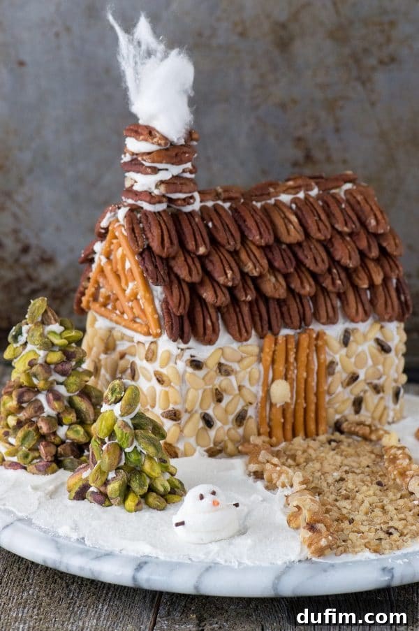 Festive Gingerbread Folly 2 Rustic gingerbread house adorned with nuts, showcasing pine nut siding and pecan roof shingles.
