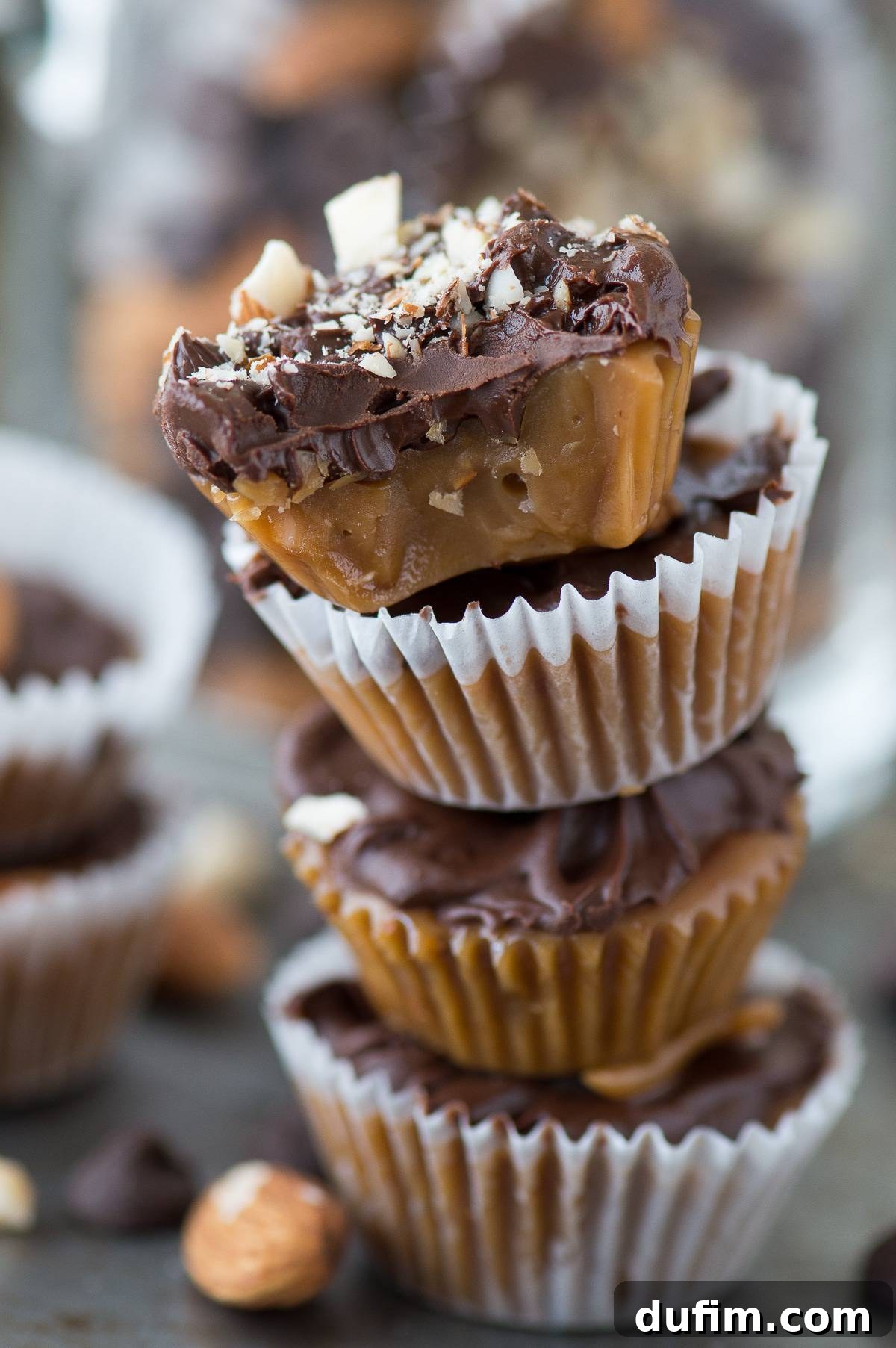 Three different decorated almond toffee bites: one with plain chocolate, one with chocolate and a whole almond, and one with chocolate and chopped almonds.