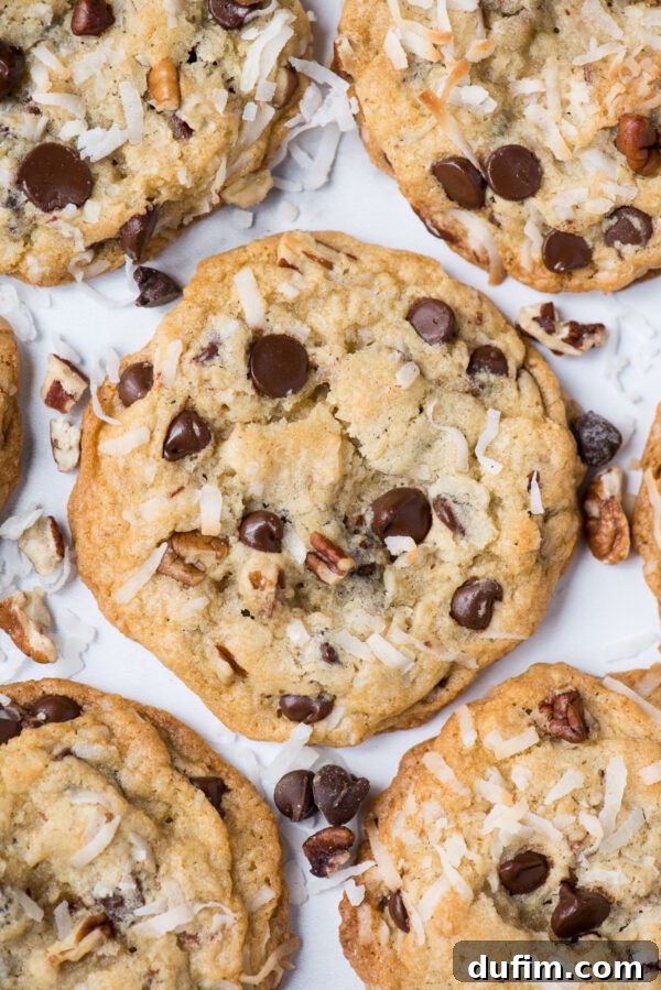 A single perfectly baked Cowboy Cookie showcased on a clean white background, highlighting its texture and delicious mix-ins.