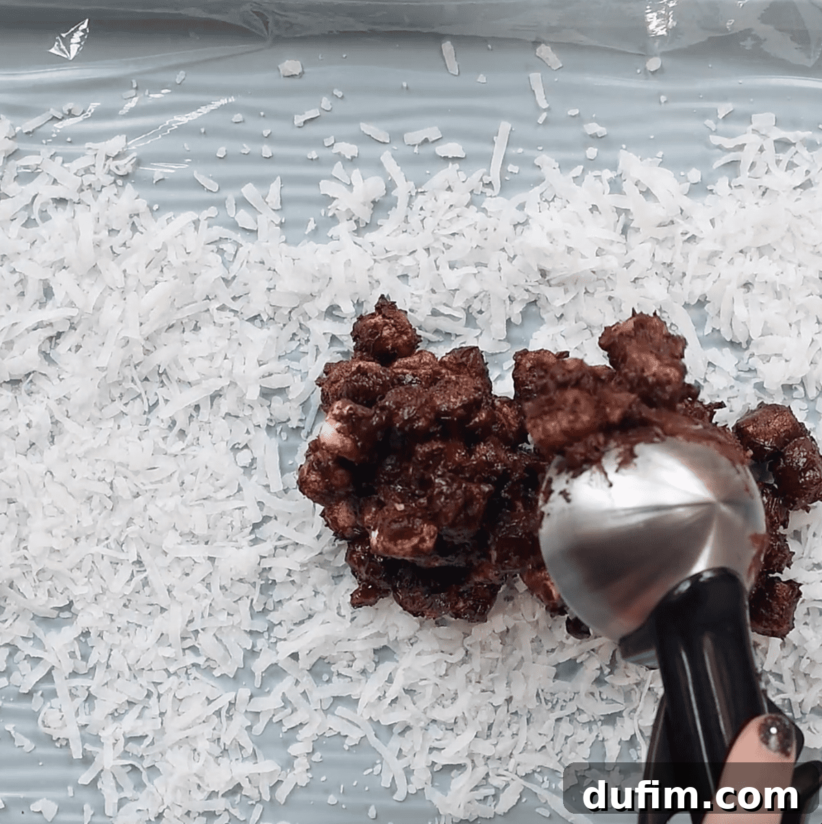shredded coconut and chocolate marshmallows mixture spread over plastic wrap