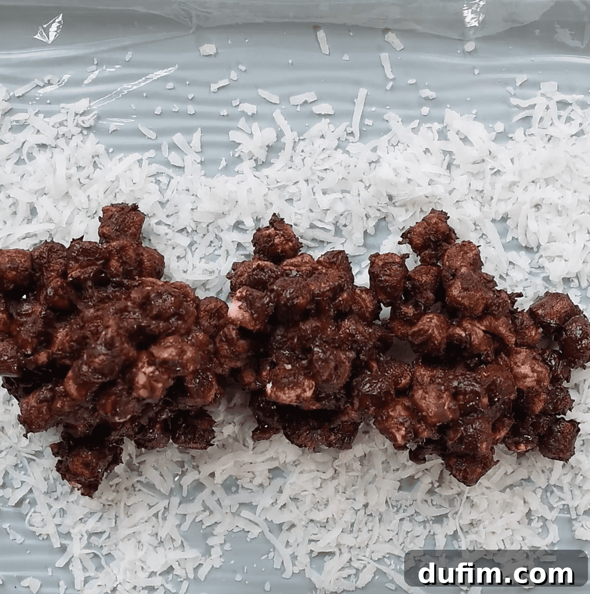 shredded coconut and chocolate marshmallows mixture spread over plastic wrap